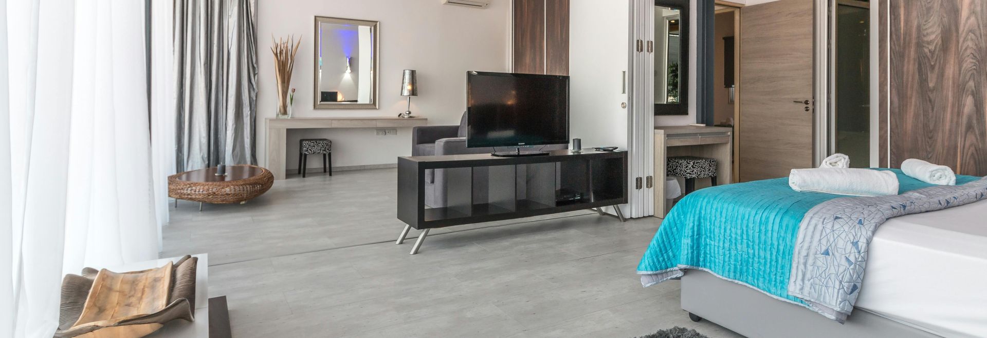 Spacious and modern bedroom with sleek design, featuring elegant decor and natural lighting.